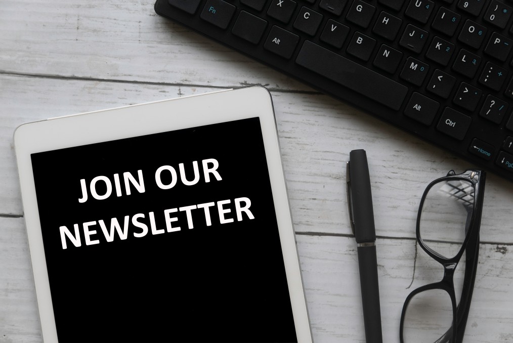 top-view-of-computer-keyboard-glasses-pen-and-tablet-written-with-join-our-newsletter-on-white-wooden_t20_N0BLer Newsletter